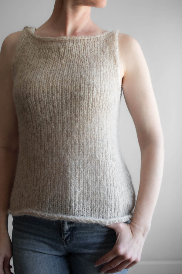 A model wearing a handknitted brushed alpaca tank top in oatmeal, shown from the front angle.
