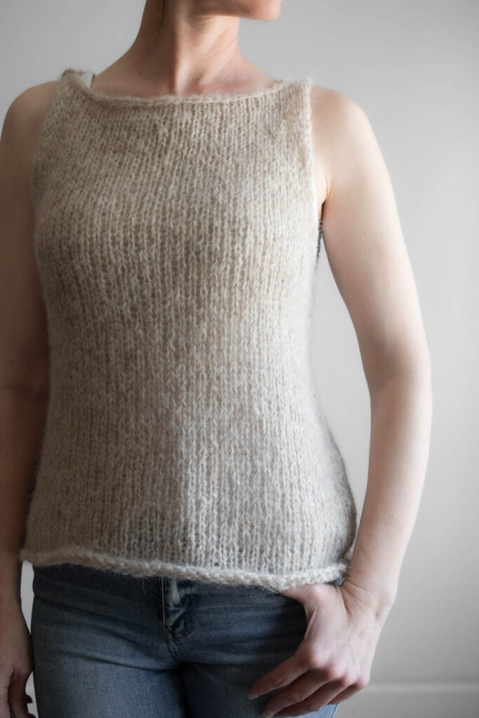 A model wearing a handknitted brushed alpaca tank top in oatmeal, shown from the front angle.