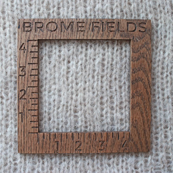 Close-up detail of a knit brushed alpaca tank top, measured with a wooden 4-inch gauge ruler engraved with “Brome Fields.”